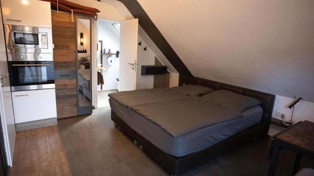 a bedroom with a bed and a kitchen with a staircase at Ferienwohnung Xantener Südsee in Xanten