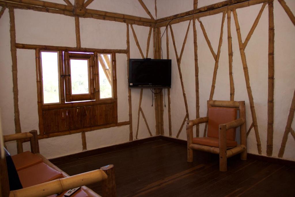 Una televisión o centro de entretenimiento en Hotel La Montoya