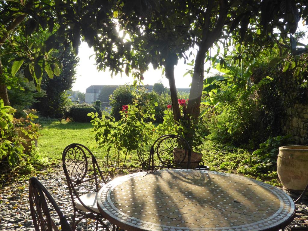 ディナンにあるAppartement des Rempartsの日光浴ができる庭園内のテーブルと椅子