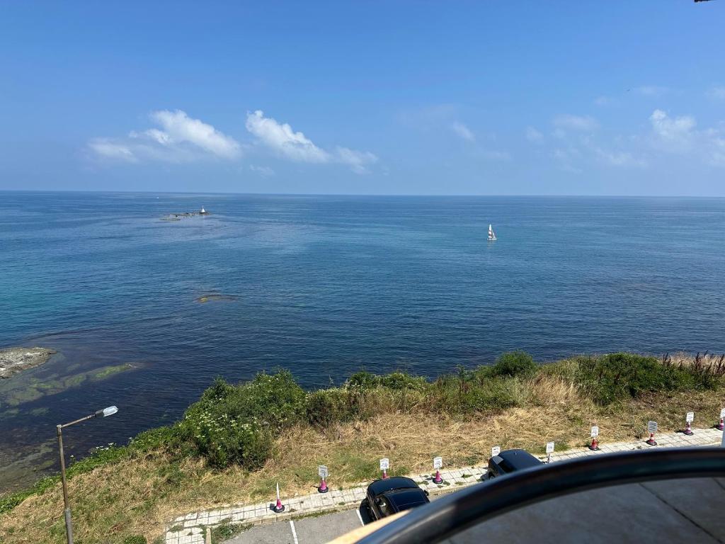a view of a large body of water with a sail boat at стаи за гости Гергана in Tsarevo