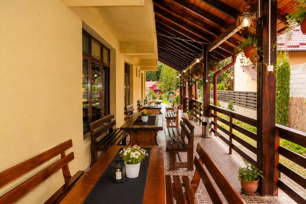 an outdoor patio with wooden benches and tables at Pension Valeria in Voronet