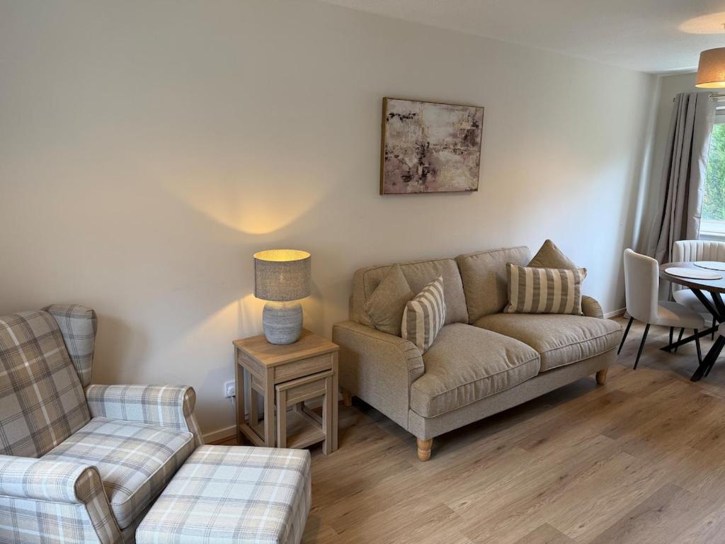 a living room with a couch and a table at The Narrows - Macaulay Letting in Rhu