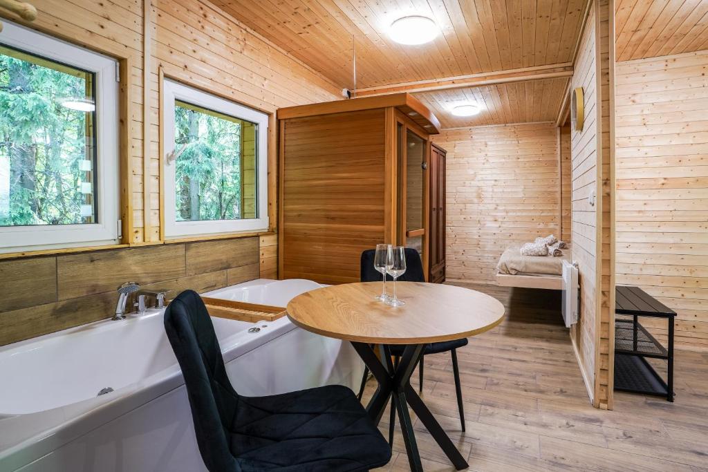 a bathroom with a tub and a table and a tub and a sink at Mama Chata a Mama Spa Beskydy in Bílá