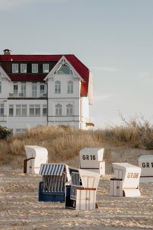 a group of chairs and a building on the beach at Strandhotel Ostende Adults Only in Ahlbeck