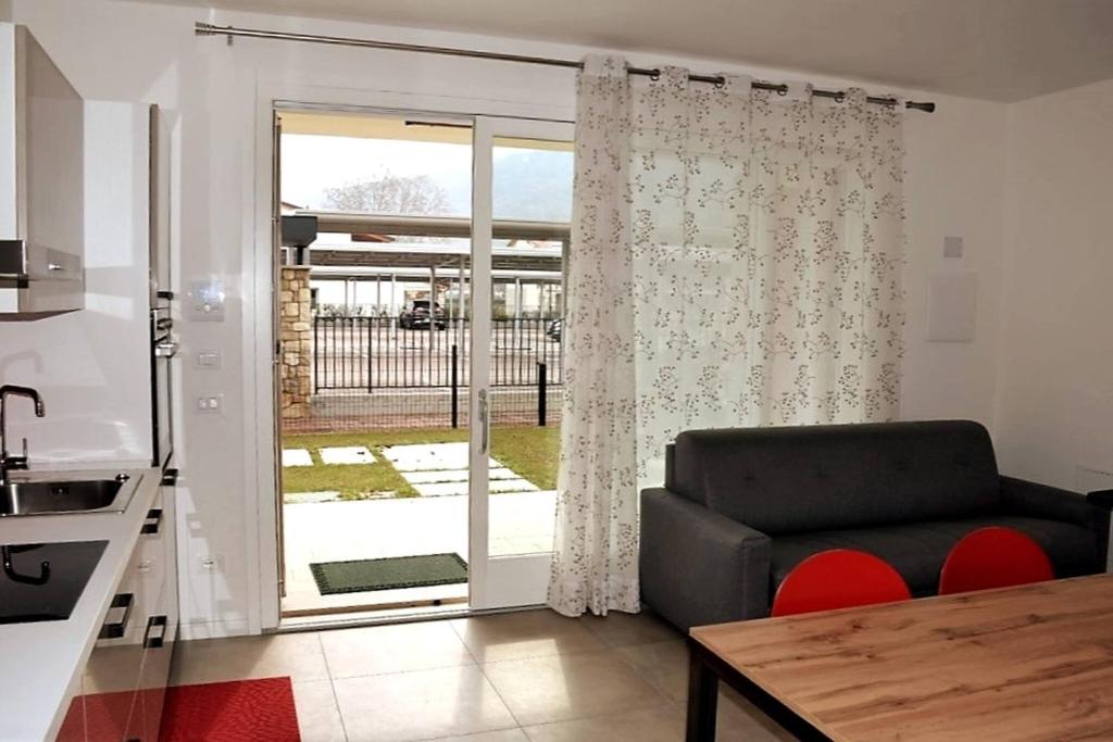 a living room with a couch and a sliding glass door at Villetta Pima in Garda