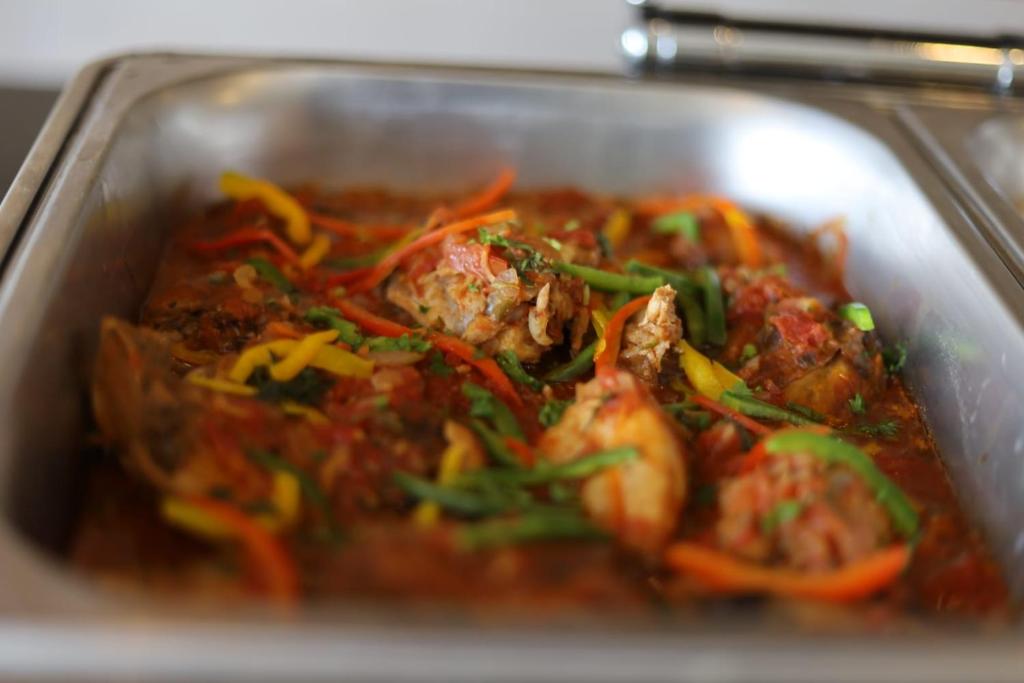 a dish of food with meat and vegetables in a pan at Sebai Laxury Suit in Nairobi