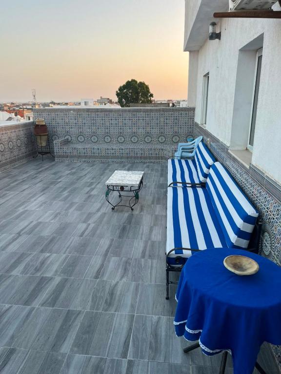 two beds on a rooftop with a table and a table at Dar zgolli in Kelibia
