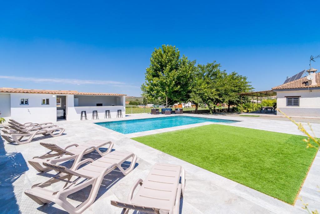 a swimming pool with chaise lounge chairs and a yard at Cubo's Maipa Rural House in Loja