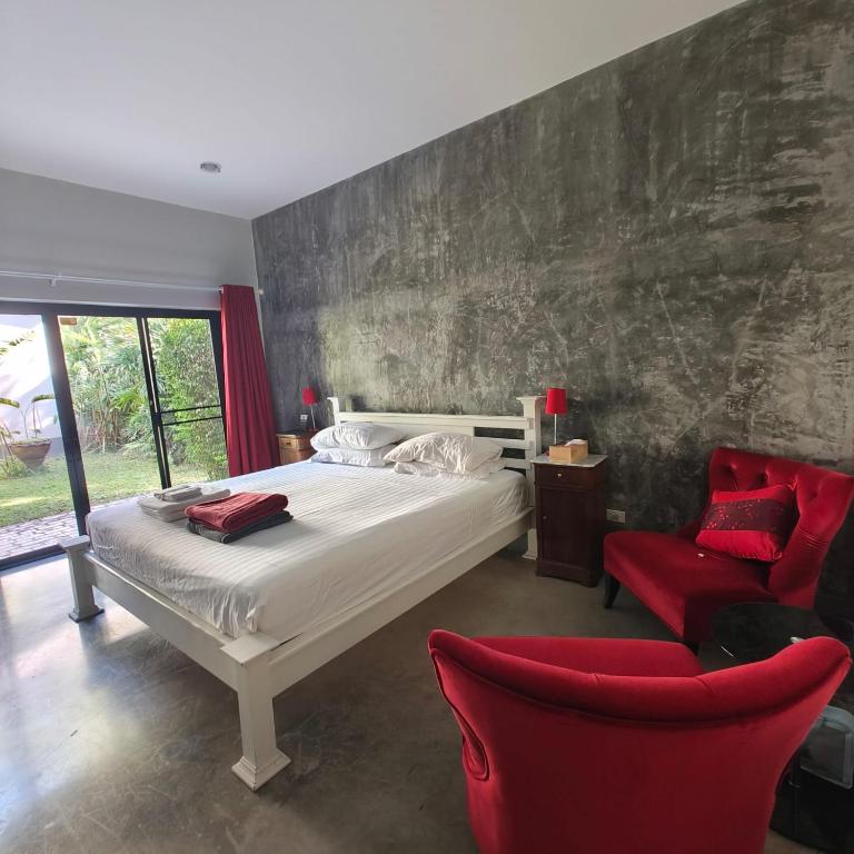 a bedroom with a white bed and a red chair at Krabi Home and Beyond-Ao Nang in Ao Nang Beach