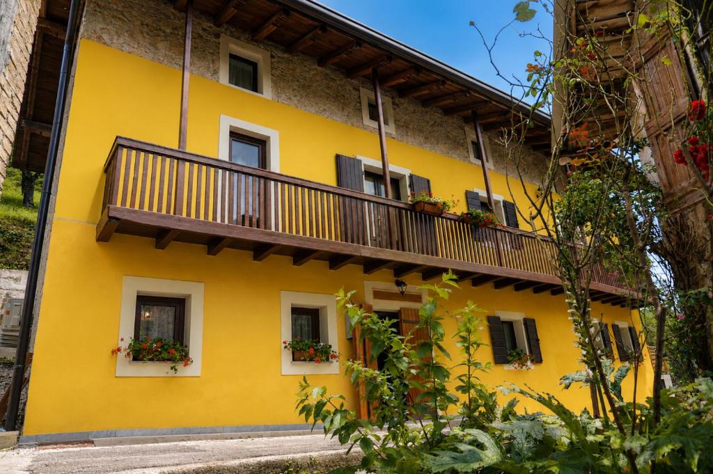 a yellow building with a balcony at Casa Runcis in Cavasso Nuovo