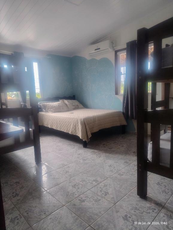 a bedroom with a bed and a blue wall at hostel xamã in Flecheiras