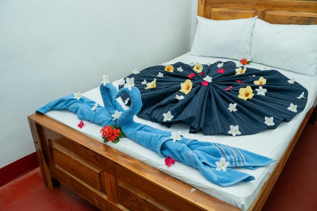 a bed with a blue comforter on it at Nilaveli Beach Bungalow in Trincomalee