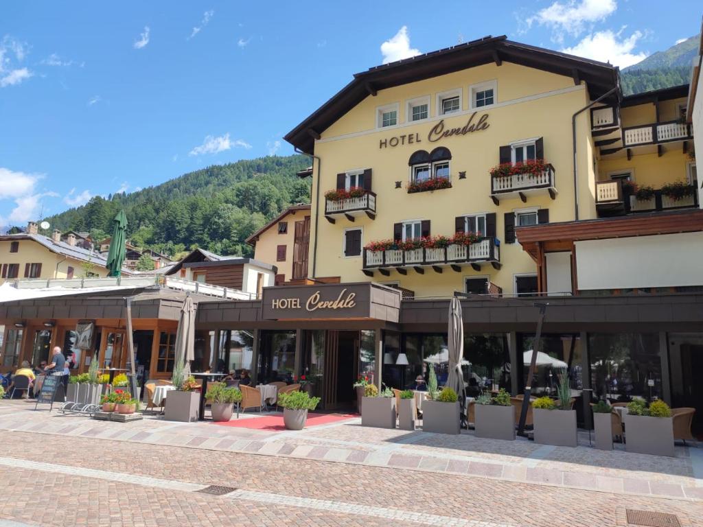 a building in a town with people sitting outside at Cevedale Living Romance Hotel in Cogolo