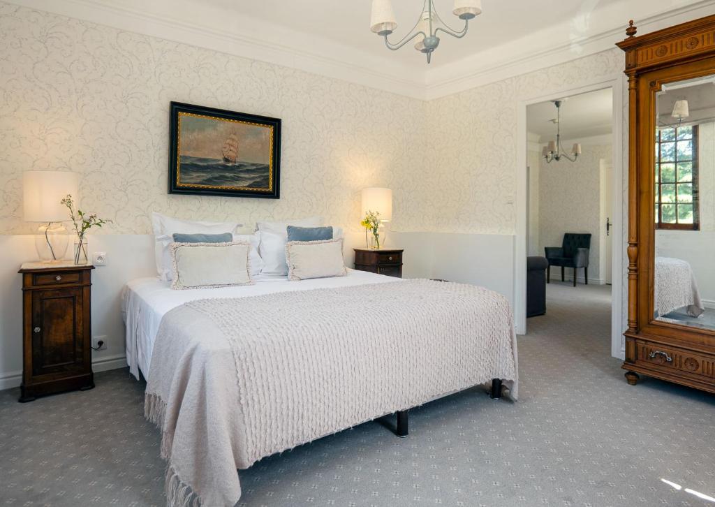 a bedroom with a large white bed with two pillows at Château de Fontager in Serves-sur-Rhône