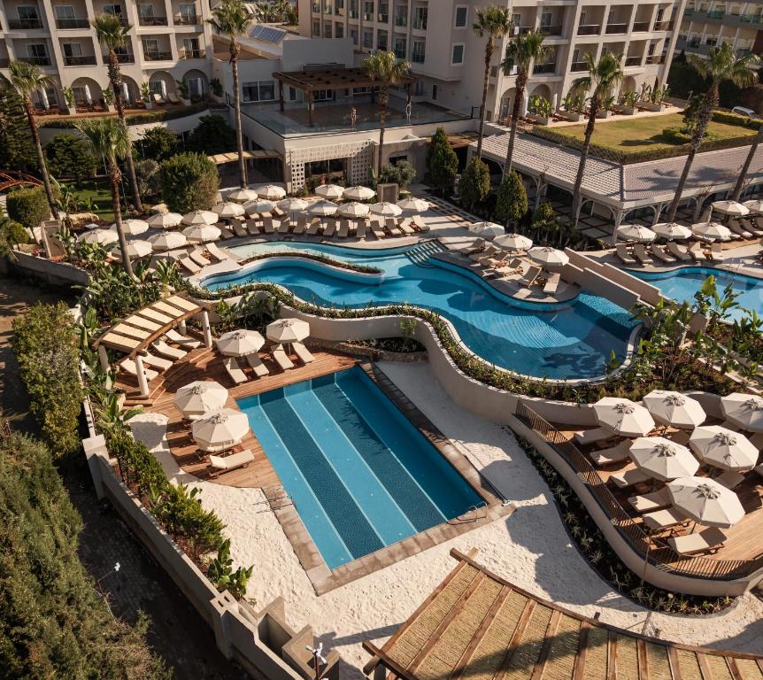 an aerial view of a resort pool with umbrellas and chairs at Adalya Bliss in Side