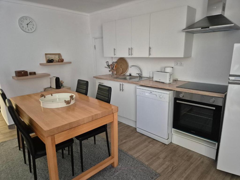 a kitchen with a wooden table and white appliances at Casa Branco in Borba