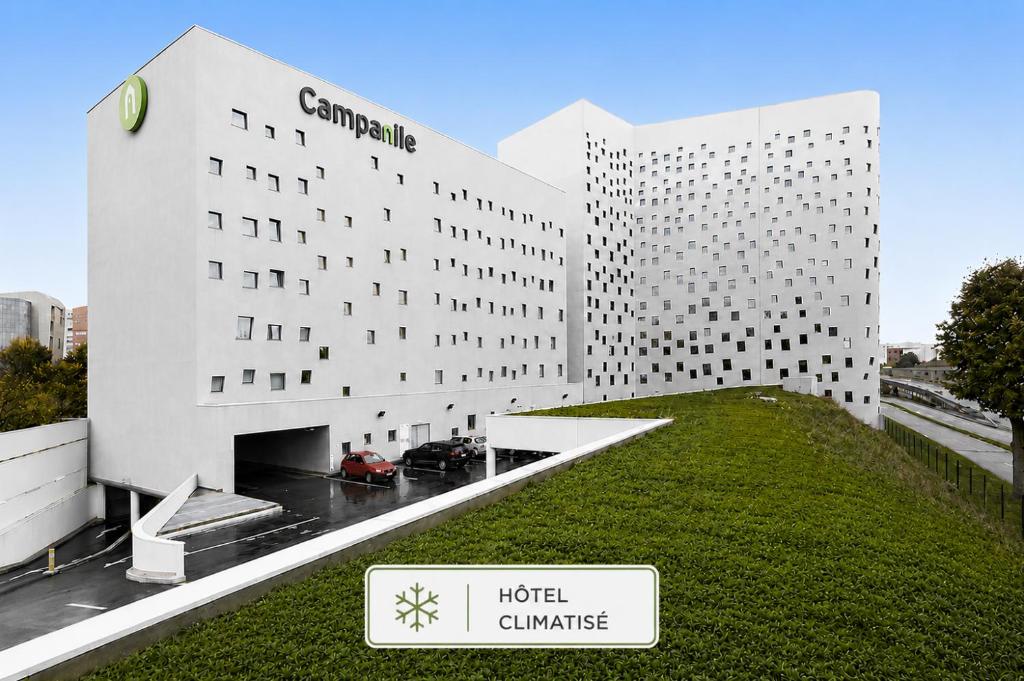 a hotel building with a green lawn in front of it at Campanile Lille Euralille in Lille