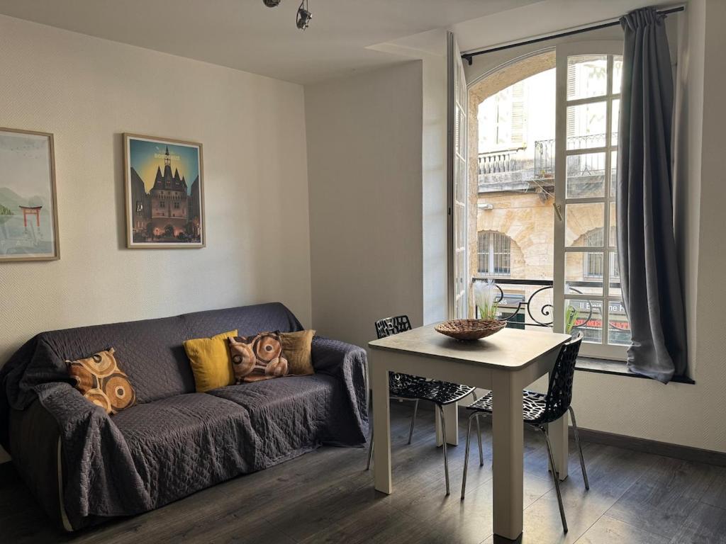 a living room with a couch and a table and a window at Superbe appartement cosy Centre Bordeaux in Bordeaux