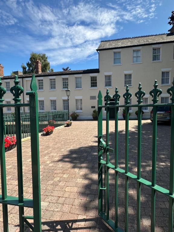 a green fence in front of a building at St Winefride's Guesthouse in Holywell
