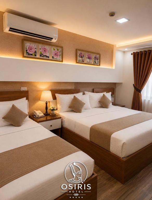 a hotel room with two beds and a air conditioner at Osiris Hotel Downtown in Cairo