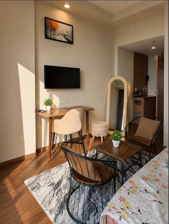 a living room with a table and chairs and a television at The Skyline Studio in Greater Noida