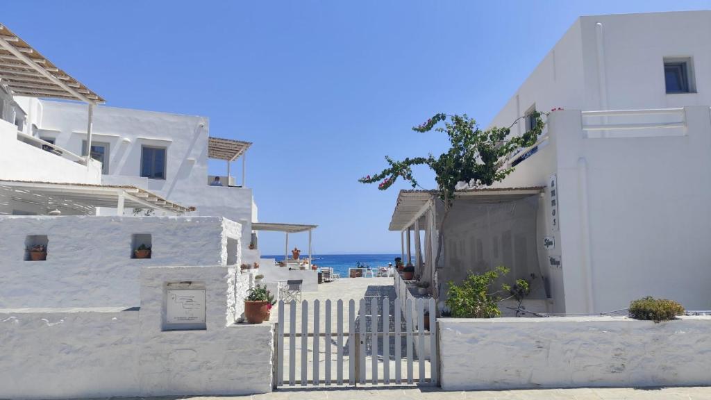 a white building with the ocean in the background at Ammos Sifnos Village in Platis Gialos