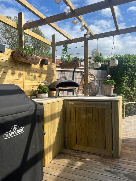 a wooden bar on a wooden deck with potted plants at Skiftehuset in Ytterby