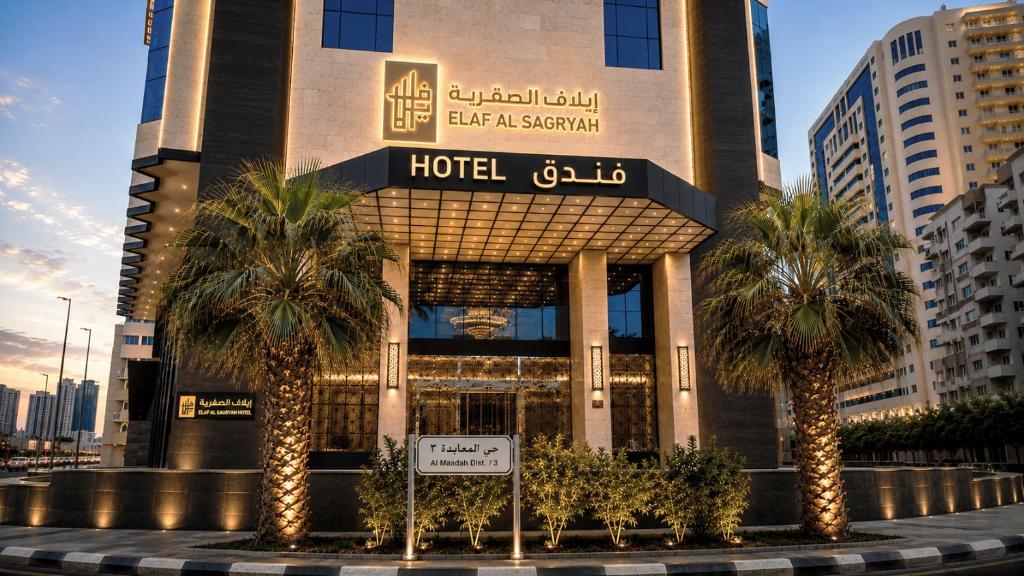 a hotel building with palm trees in front of it at Elaf Al Sagryah Hotel in Mecca