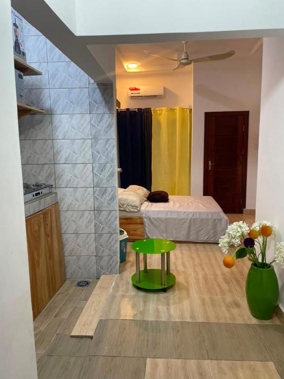 a small room with a bed and a green table at Smart Residences Apart Go in Cotonou