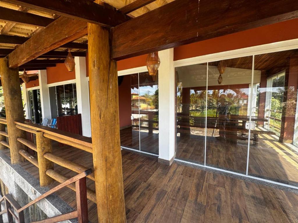 a porch of a house with glass windows at Recanto Praia do Sargi in Uruçuca