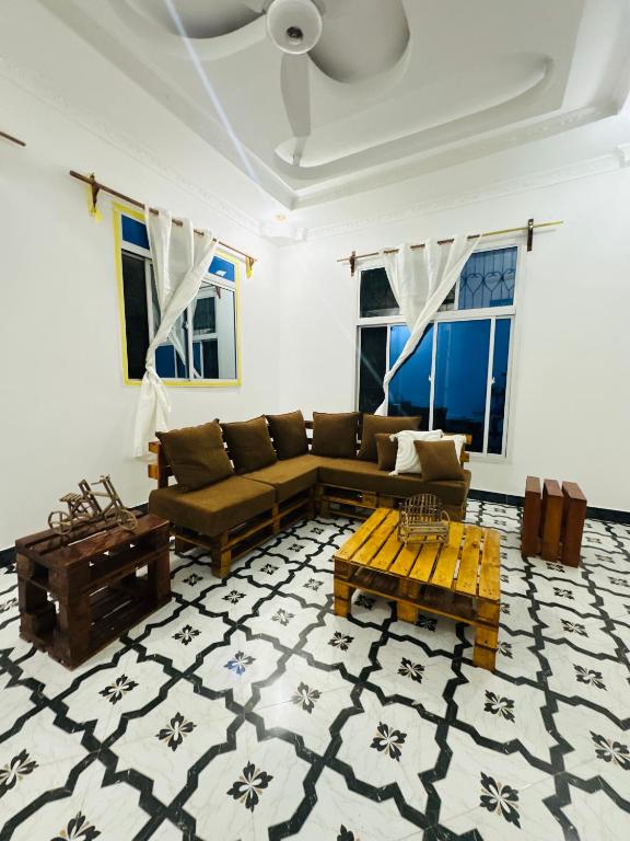 a living room with a couch and a table at Brown & White House in Paje