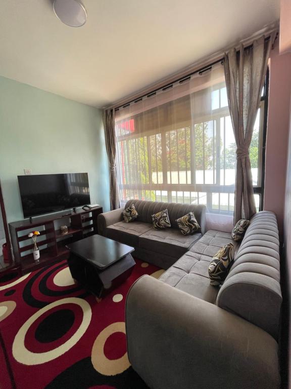 a living room with a couch and a tv at Casa Bnb kisumu in Kisumu