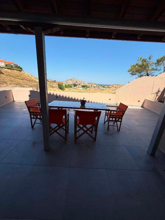 a ping pong table and chairs on a patio at Mirina View Apartment #2 in Myrina