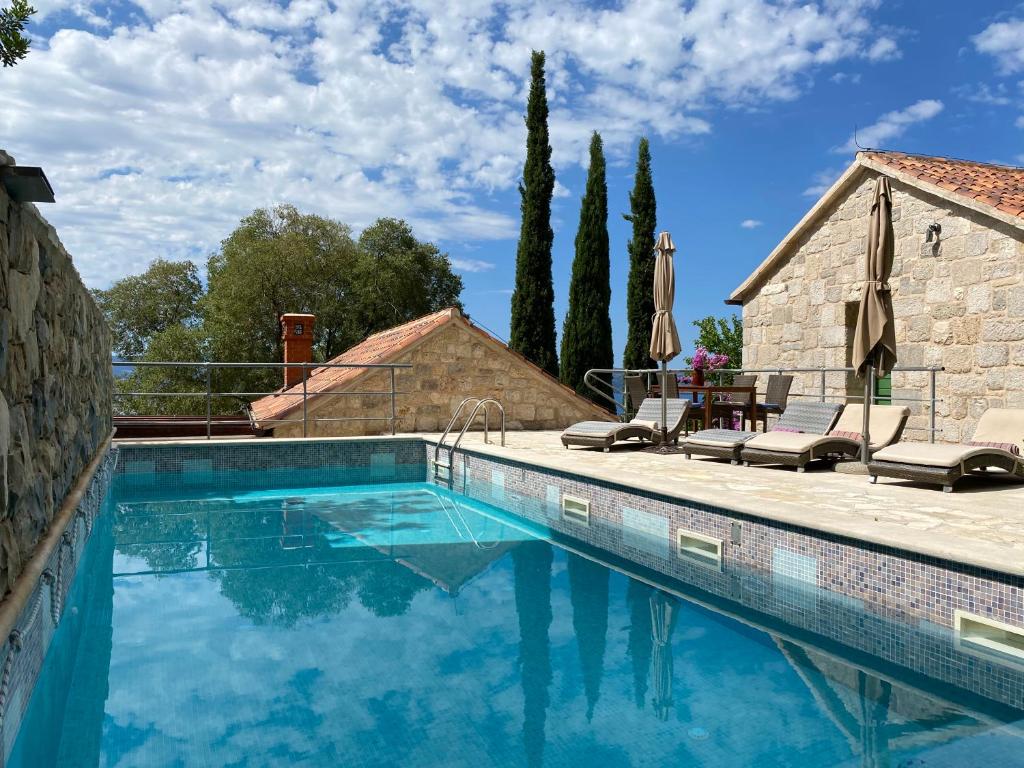 a swimming pool with blue water in front of a house at Villa Nidus Onei in Omiš