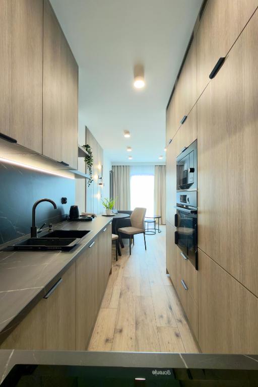 a kitchen with wooden cabinets and a counter top at Apartament Stara Fabryka 32 in Włocławek