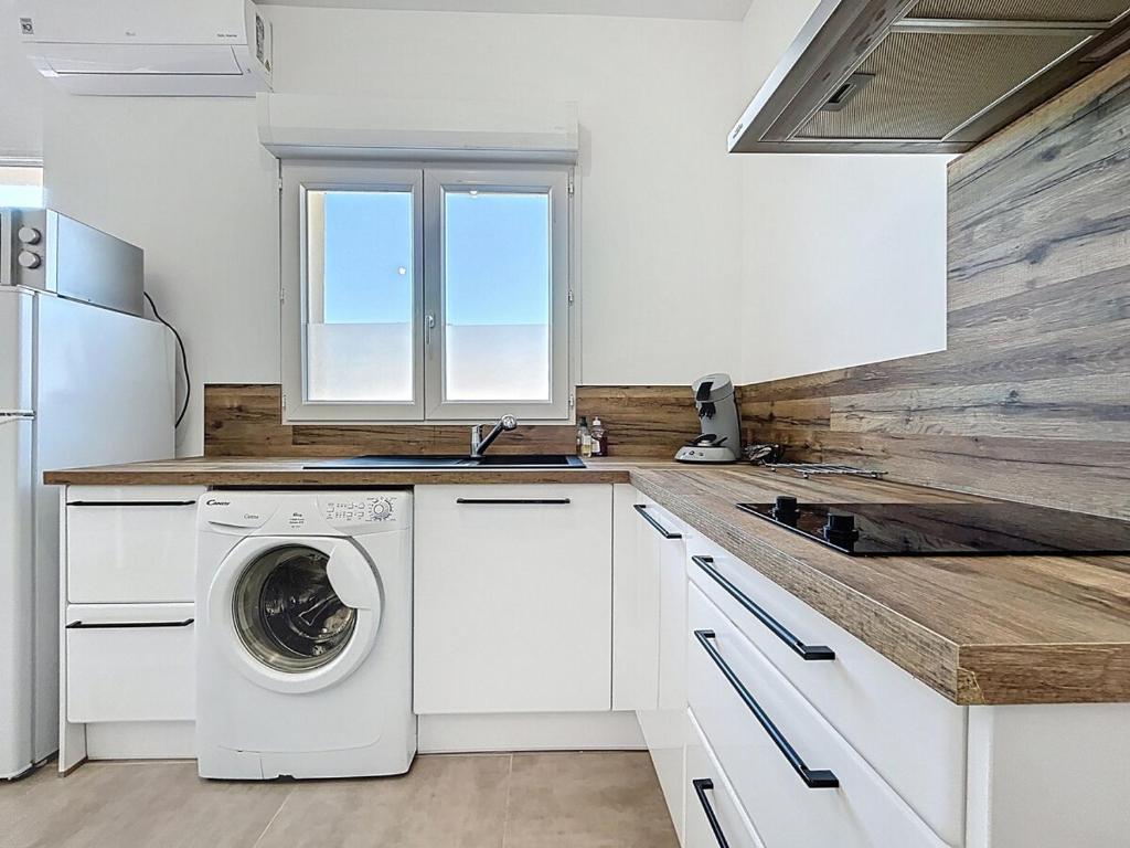 a kitchen with a washer and dryer on a counter at Studio avec terrasse en rez de chaussée in Lapalme