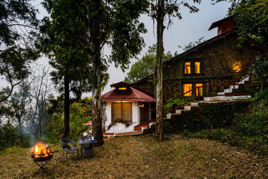 a house with a fire in front of it at Kumaon Cottage, Nainital - AM Hotel Kollection in Nainital