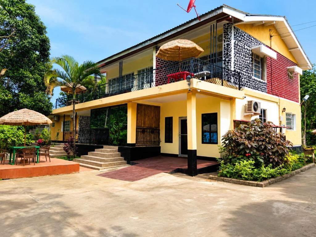 a yellow and red building with a balcony and a table at Safari Resot Star One in Moshi