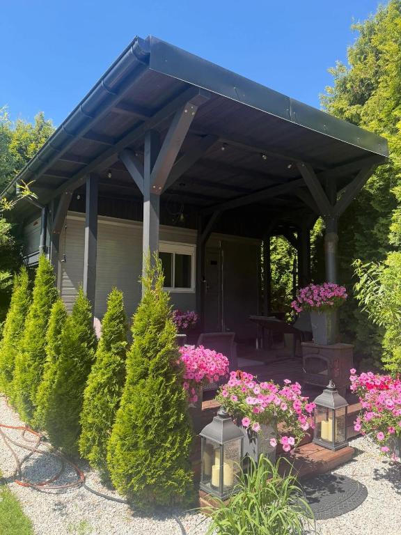 a patio with a black awning and flowers and trees at Lumobile in Gryfice