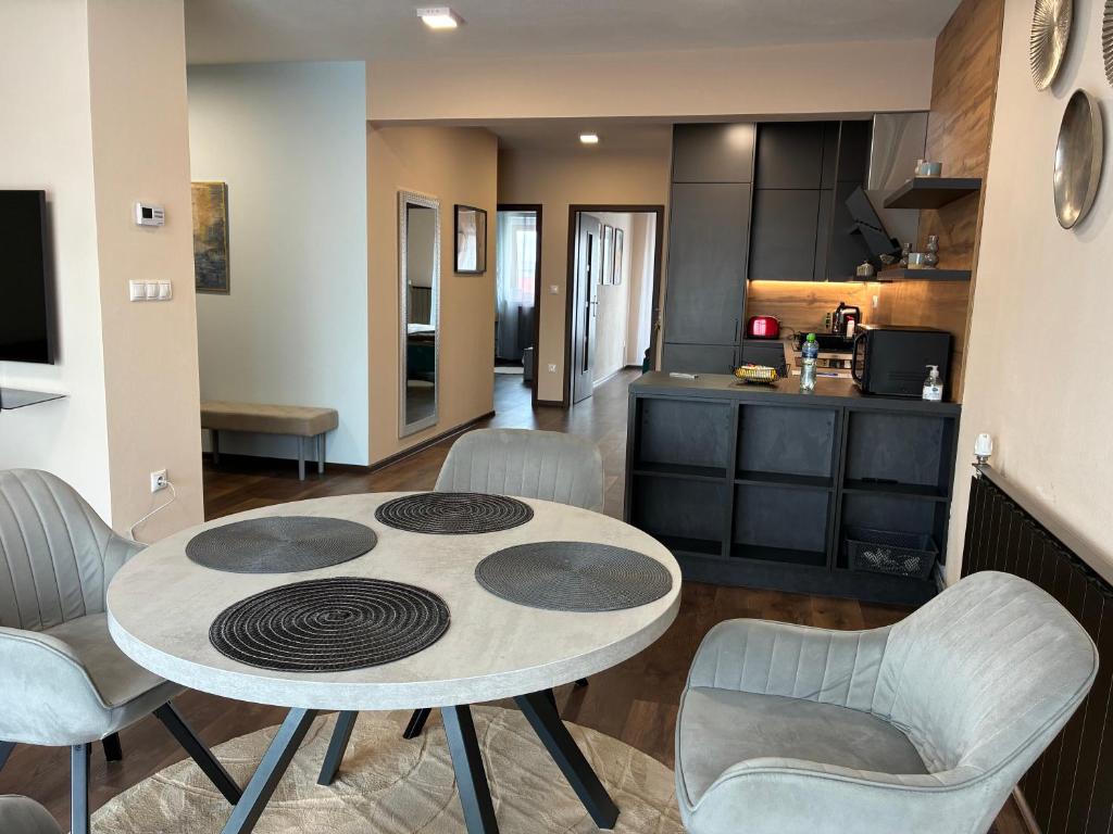 una cucina e un soggiorno con tavolo e sedie di Esterhazy Apartman a Galanta