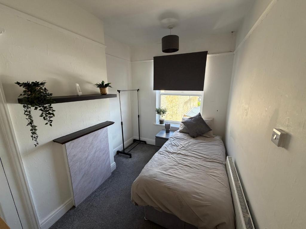 a small bedroom with a bed and a fireplace at 86 Watling in Gillingham