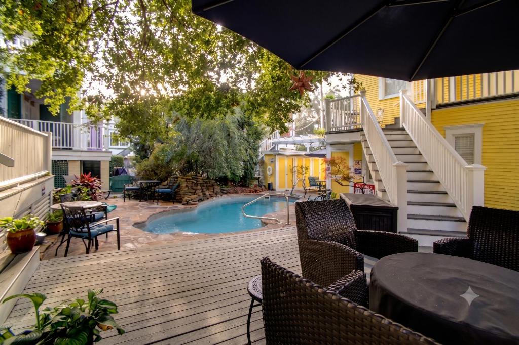 an outdoor deck with a pool and tables and chairs at Azalea Inn and Villas in Savannah