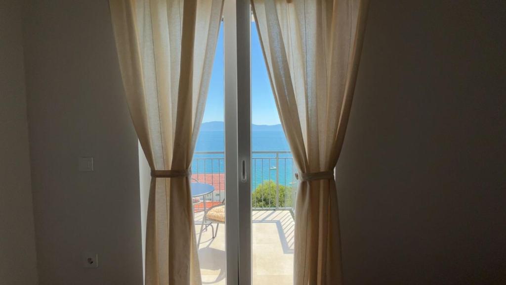 a sliding glass door with a view of a patio at Apartmani Alexa 2 in Brist