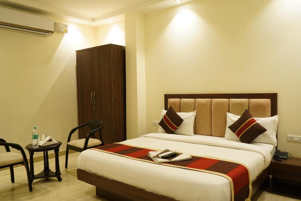 a hotel room with a large bed and a chair at Hotel High Residency in New Delhi