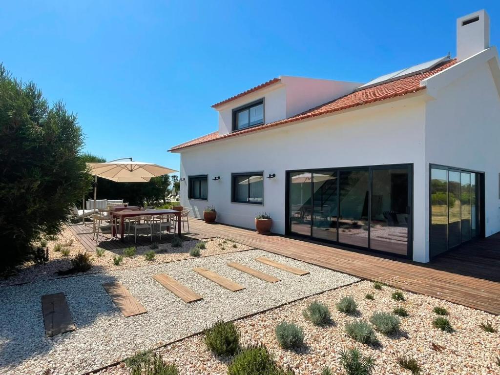 a white house with a patio and a table at Monte da Fonte in Odemira