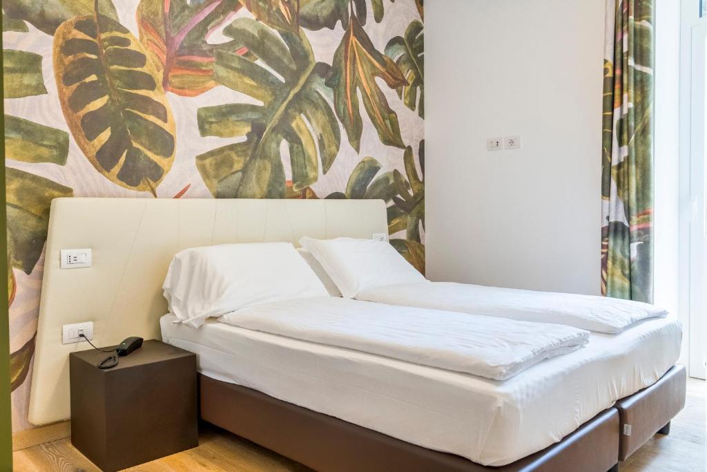 a bed in a room with a painting on the wall at lillil - Popping Holiday in Riva del Garda