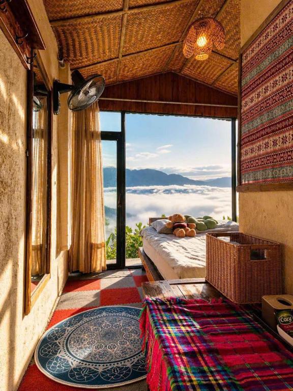 a bedroom with a bed and a large window at Charming Home Tà Xùa in Bắc Yên