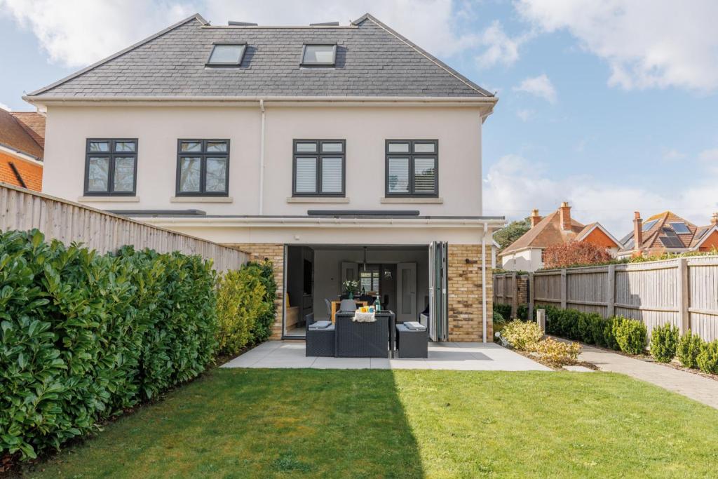 a large white house with a fence at The Laurels by Grandeur Property in Poole