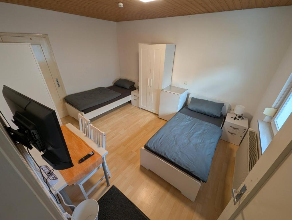 a small room with two beds and a television at Härtsfeldwohnungen in Neresheim