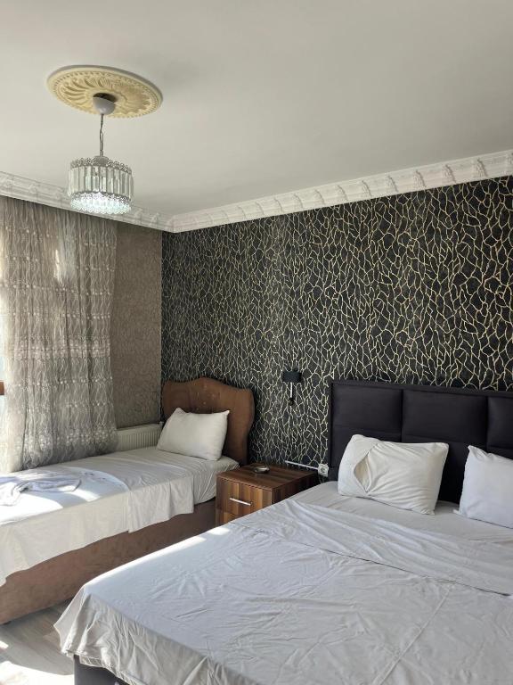 a bedroom with two beds and a wall at VAN SERHAT Pansiyon in Ipekyolu